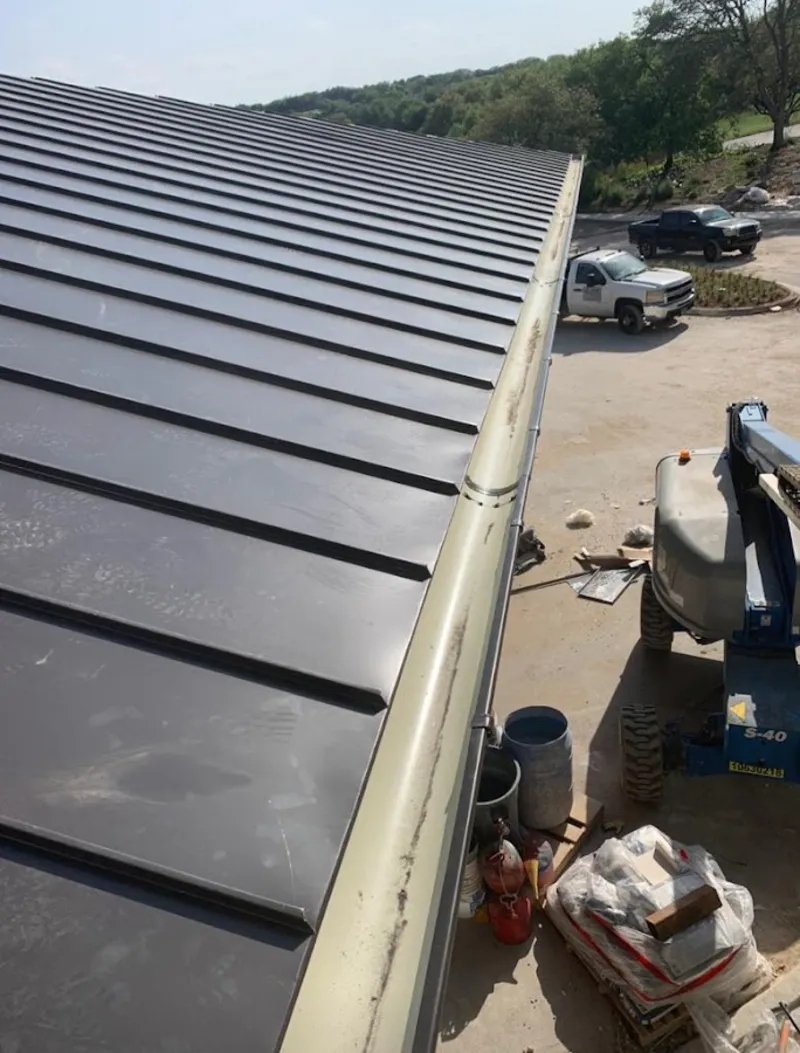 Standing seam panel and gutter detail on a metal roofing jobsite in Delran